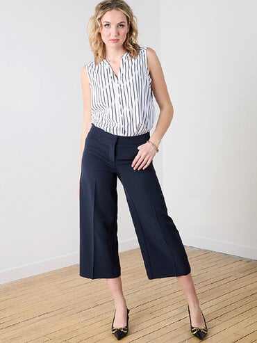 woman in wide navy pants and sleeveless striped shirt