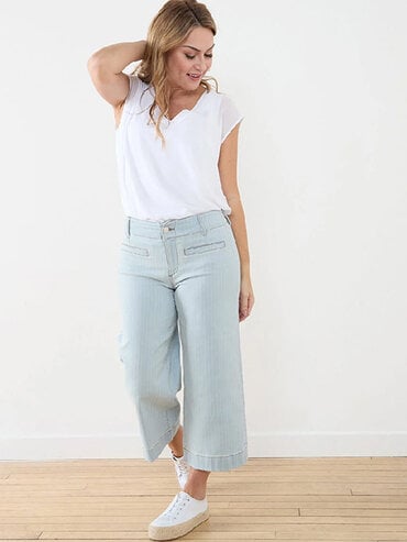 woman in wide light wash jeans and white tee